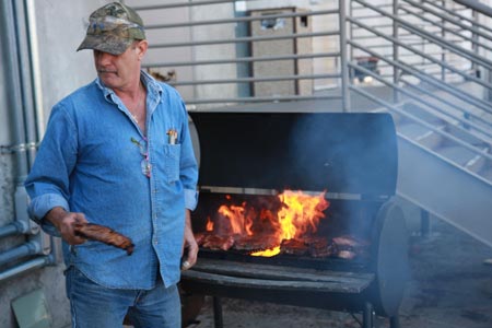 man grilling meat on a barbeque 